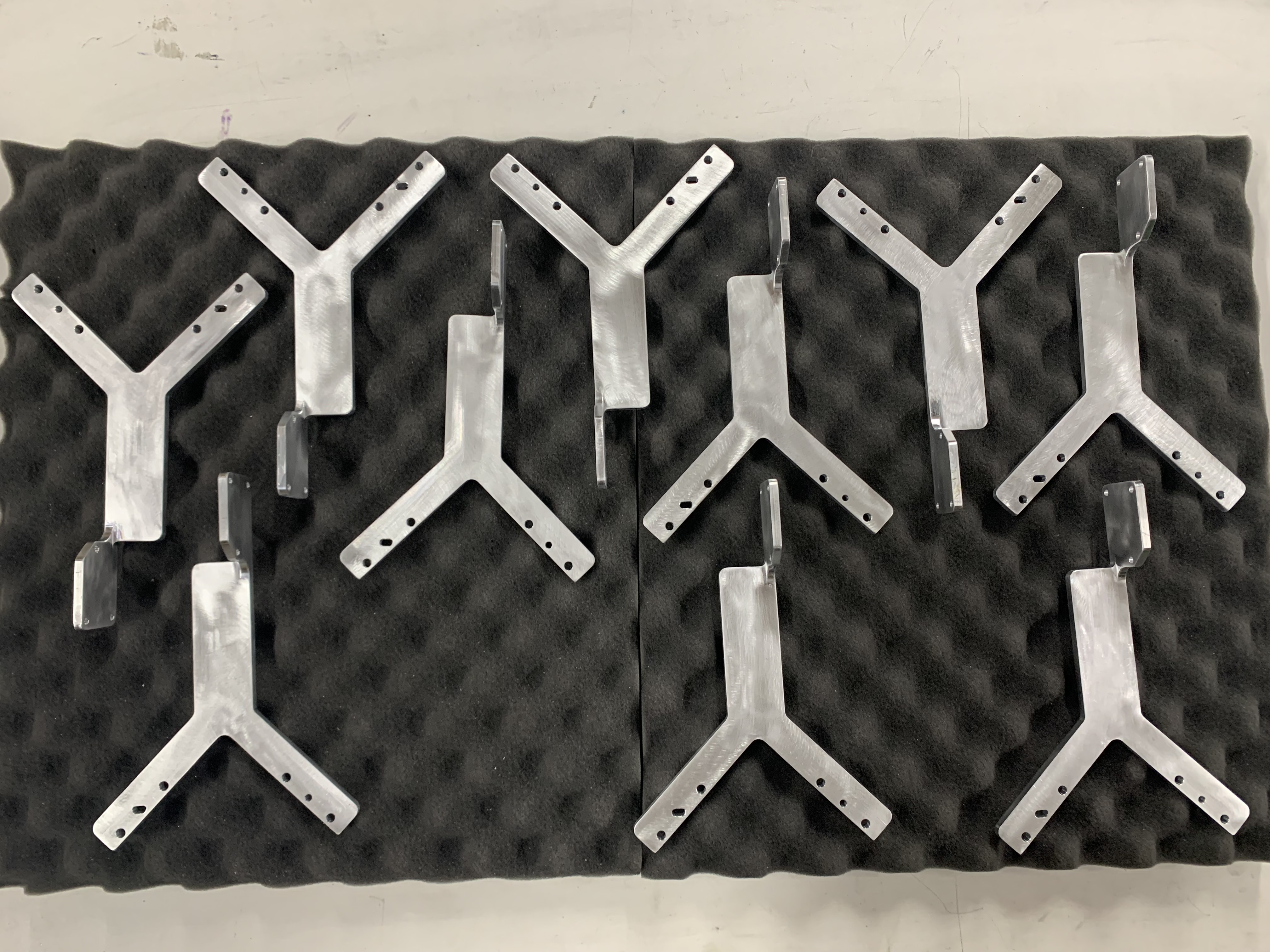 Eight polished Y-shaped metal brackets